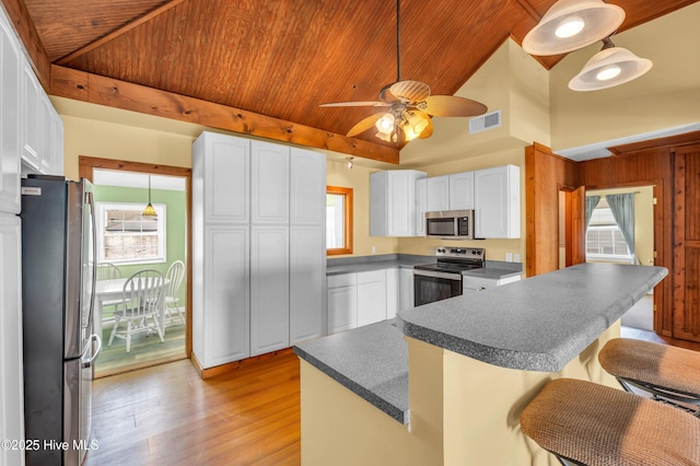 kitchen with vaulted ceiling, appliances with stainless steel finishes, wood ceiling, and visible vents