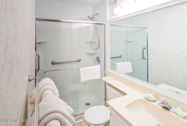 bathroom featuring vanity, toilet, and a shower stall