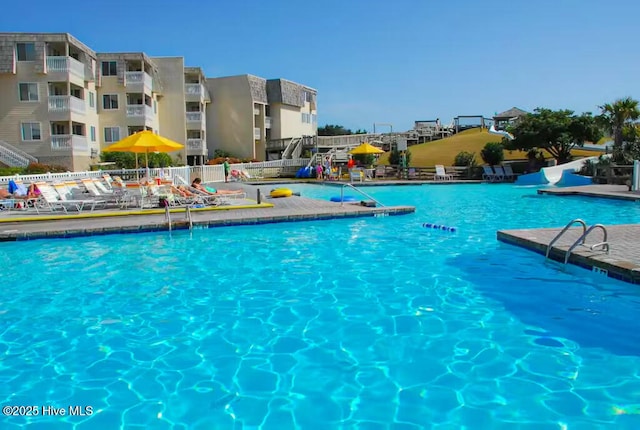community pool with a patio and fence