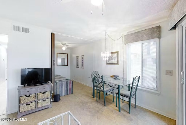 dining area with visible vents, baseboards, and ceiling fan with notable chandelier