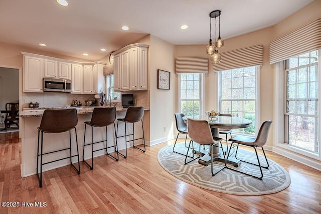920 Diamondhead Dr S, Pinehurst, NC 28374 - kitchen featuring white cabinets, stainless steel microwave, light stone countertops, and a wealth of natural light