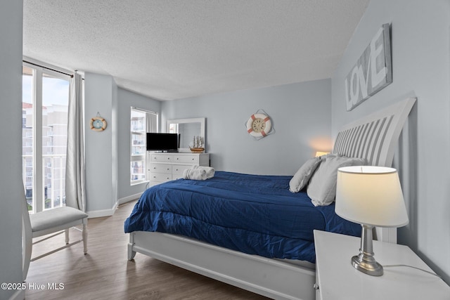 2000 New River Inlet Rd Unit 3302, North Topsail Beach, NC 28460 - bedroom with a textured ceiling, multiple windows, and wood finished floors
