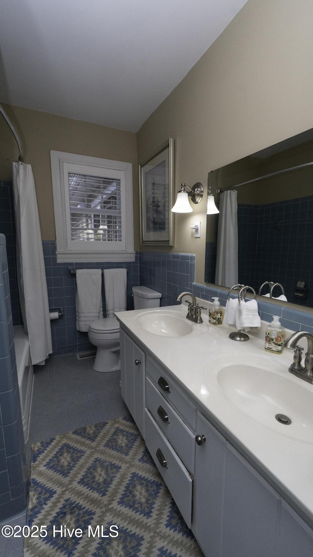 1914 Howard Ave, Tarboro, NC 27886 - bathroom featuring tile walls, toilet, tile patterned flooring, and a sink