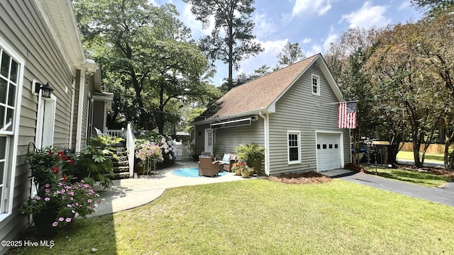 1914 Howard Ave, Tarboro, NC 27886 - view of property exterior featuring aphalt driveway, roof with shingles, a garage, and a lawn