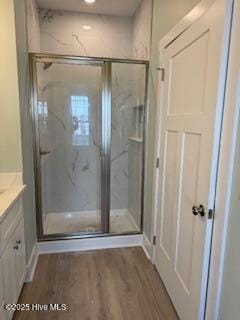 bathroom with recessed lighting, a shower stall, wood finished floors, and vanity