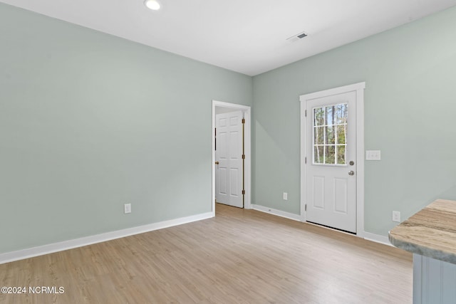 spare room featuring recessed lighting, baseboards, light wood finished floors, and visible vents