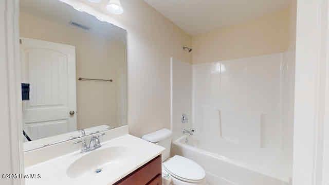 bathroom featuring vanity, shower / bathtub combination, and toilet