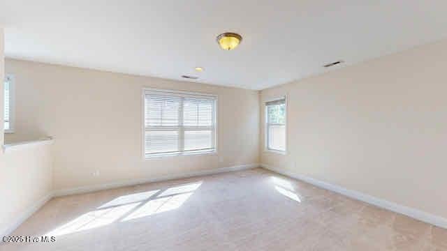 carpeted empty room featuring baseboards