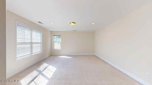 spare room featuring recessed lighting, baseboards, and light colored carpet