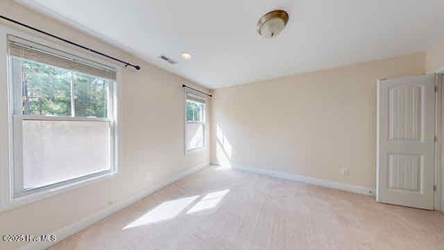 unfurnished room featuring baseboards and light carpet