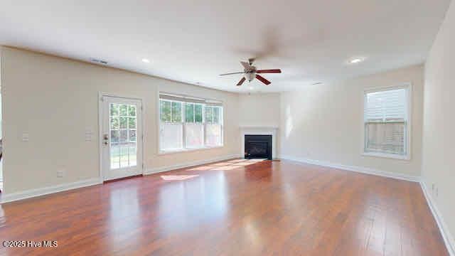 unfurnished living room featuring a fireplace, a ceiling fan, baseboards, recessed lighting, and wood finished floors