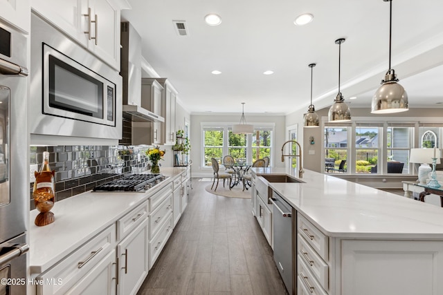 kitchen with visible vents, appliances with stainless steel finishes, a large island with sink, recessed lighting, and dark wood-type flooring