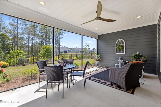sunroom / solarium featuring a ceiling fan and outdoor dining area