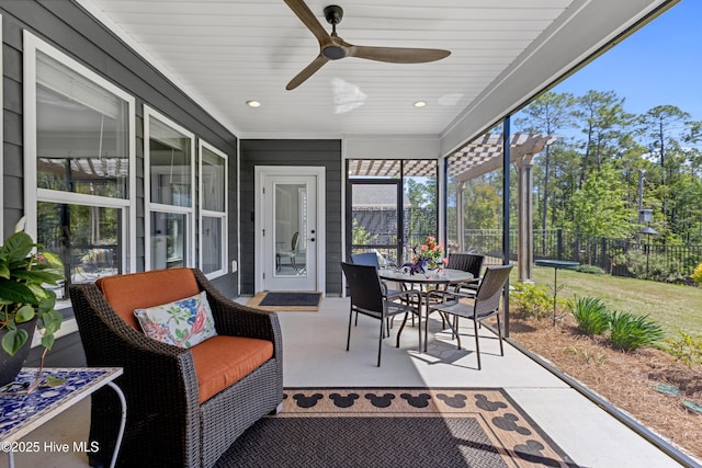 sunroom / solarium with ceiling fan and outdoor dining space