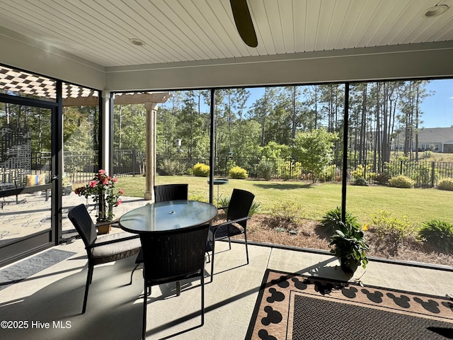 sunroom / solarium with a ceiling fan and outdoor dining area