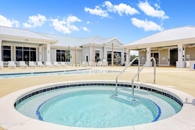 pool featuring a patio, a hot tub, and fence