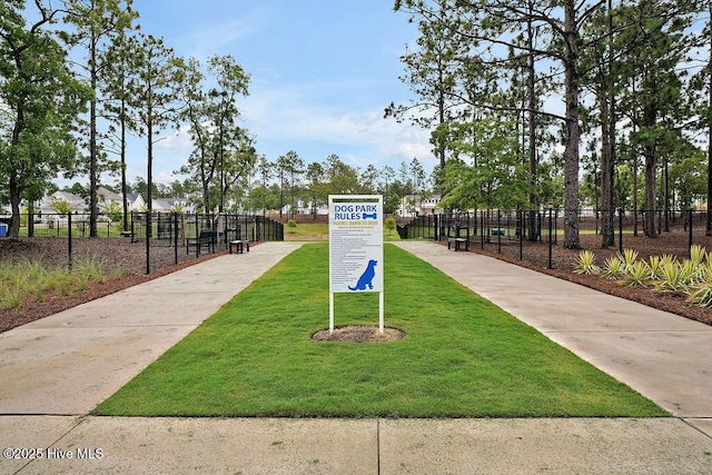 view of property's community with a lawn and fence