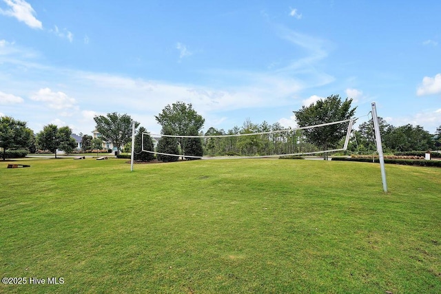 view of property's community with a lawn and volleyball court