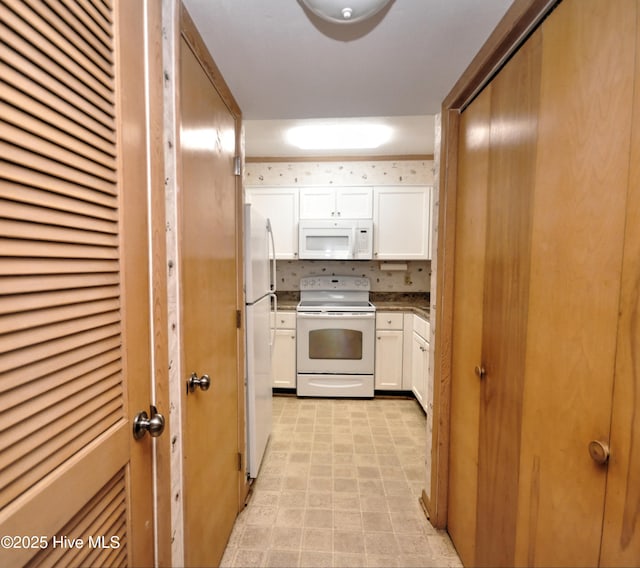 kitchen featuring white cabinets and white appliances