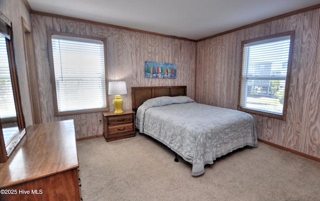 bedroom featuring wooden walls, baseboards, and carpet