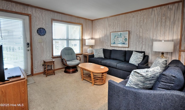 carpeted living room with crown molding and baseboards