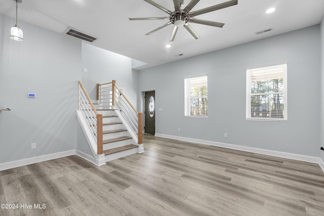unfurnished living room featuring recessed lighting, ceiling fan, visible vents, and stairway