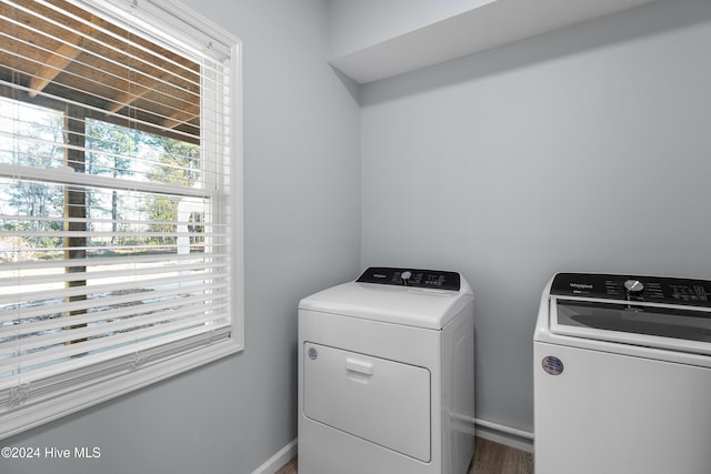 laundry room featuring baseboards, plenty of natural light, laundry area, and washing machine and clothes dryer