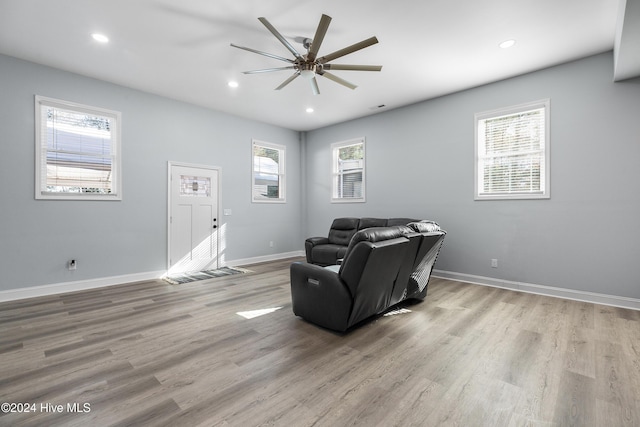 living area featuring a healthy amount of sunlight, a ceiling fan, and wood finished floors