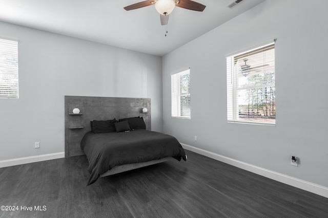 bedroom with baseboards, visible vents, a ceiling fan, and dark wood-type flooring
