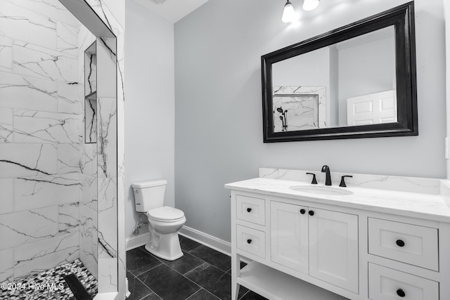 bathroom featuring vanity, marble finish floor, toilet, baseboards, and a marble finish shower