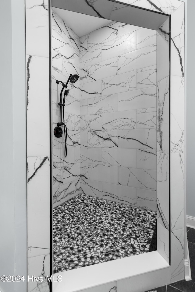 bathroom with a marble finish shower and marble finish floor