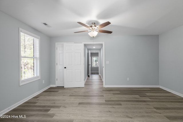 unfurnished bedroom featuring visible vents, baseboards, and wood finished floors