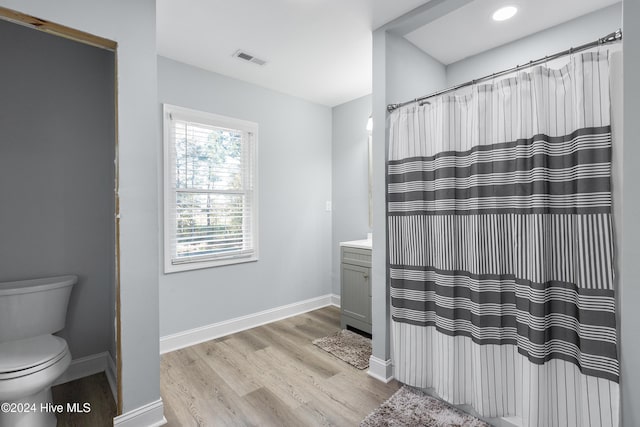 full bath featuring visible vents, vanity, wood finished floors, toilet, and baseboards