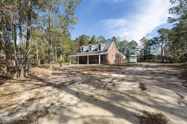 exterior space featuring covered porch and brick siding
