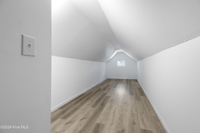 bonus room featuring baseboards, vaulted ceiling, and wood finished floors