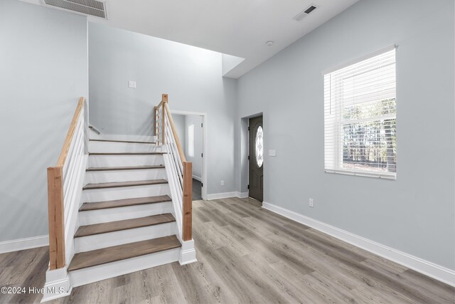 stairs featuring visible vents, baseboards, and wood finished floors