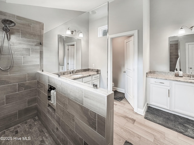 7845 Champlain Dr, Wilmington, NC 28412 - bathroom with wood finished floors, toilet, walk in shower, two vanities, and a sink