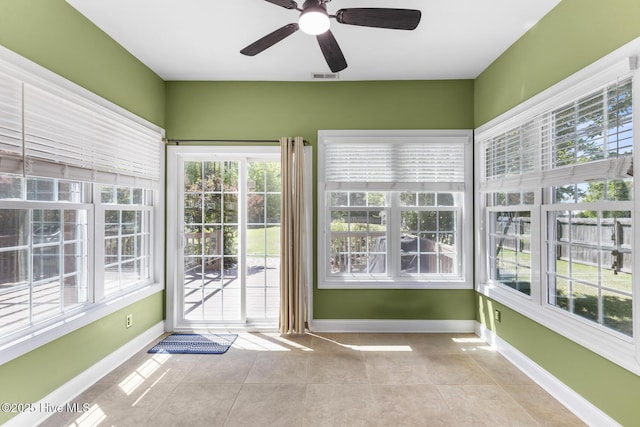 unfurnished sunroom featuring baseboards, visible vents, and tile patterned flooring