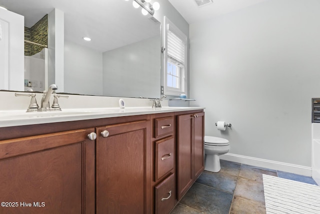 bathroom with double vanity, toilet, baseboards, walk in shower, and a sink