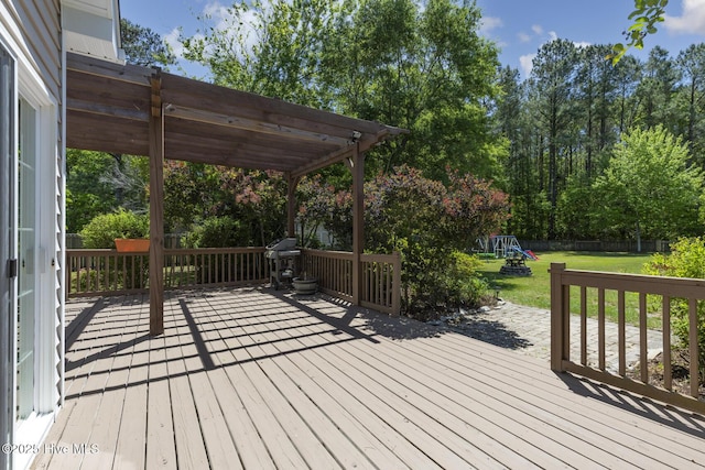 wooden deck featuring a lawn, a pergola, fence, and a playground