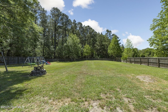 view of yard featuring a fenced backyard and a playground