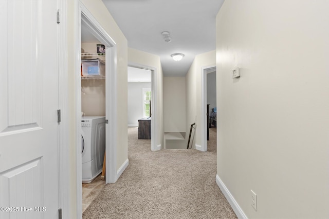 hallway with baseboards, carpet flooring, and washer / clothes dryer