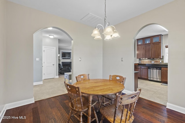 dining room featuring arched walkways, visible vents, and light tile patterned floors