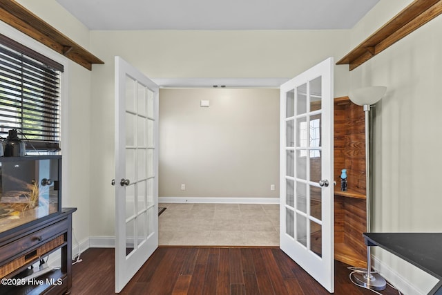 hallway featuring baseboards, french doors, and wood finished floors
