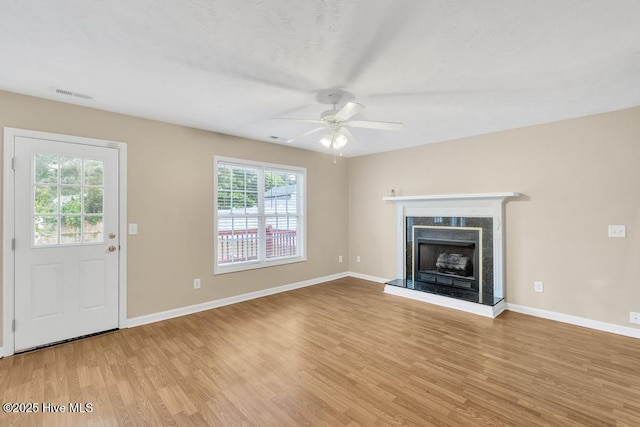 unfurnished living room featuring a ceiling fan, visible vents, plenty of natural light, and light wood-style flooring