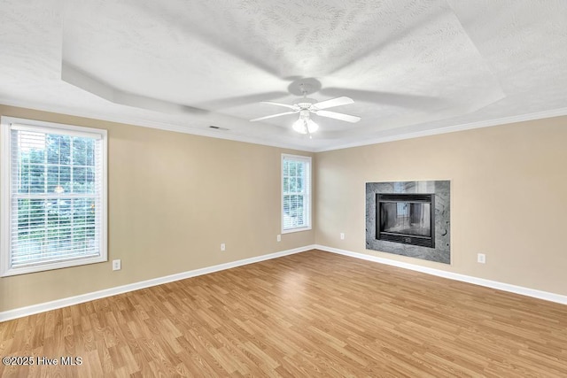 unfurnished living room with baseboards, a wealth of natural light, and light wood-style flooring
