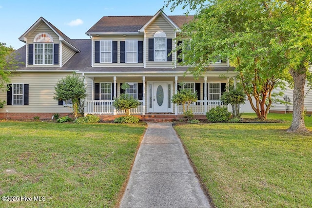 colonial-style house with covered porch, a shingled roof, and a front yard