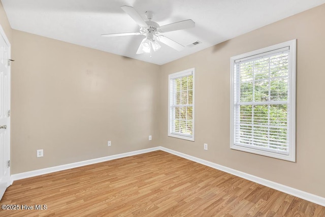 unfurnished room featuring baseboards, visible vents, and light wood-style floors