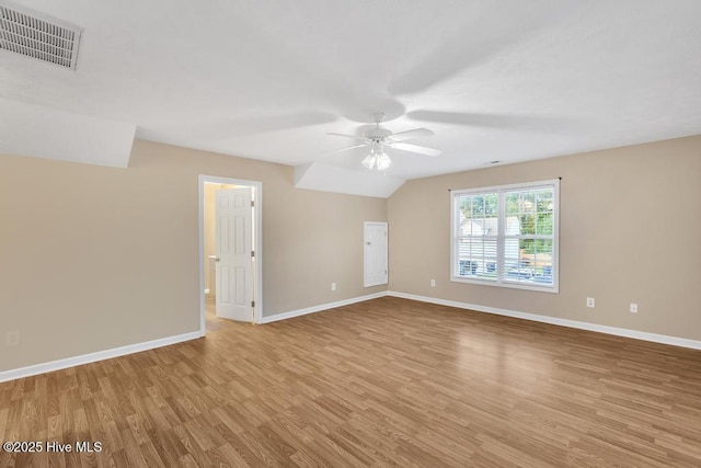 empty room with visible vents, a ceiling fan, baseboards, and wood finished floors