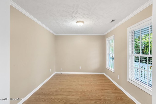 empty room featuring baseboards, a textured ceiling, visible vents, and light wood-style flooring